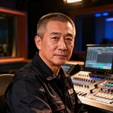 某省级广电集团技术总监头像，中年男性，穿着深色工装，背景为演播室控制台。